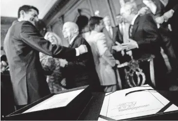  ?? [AP FILE PHOTO] ?? The signatures of Speaker of the House Paul Ryan, R-Wis., and Senate Finance Committee Chairman Orrin Hatch, R-Utah, foreground, can be seen Dec. 21 as Ryan, left, and House Ways and Means Committee Chairman Kevin Brady, R-Texas, second from left,...