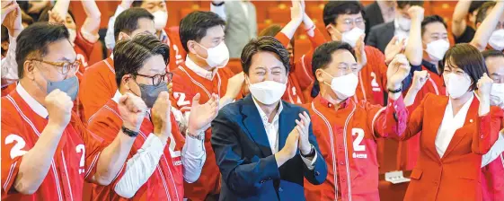  ?? Korea Times photo by Shim Hyun-chul ?? Lee Jun-seok, center in front row, chairman of the ruling People Power Party (PPP), claps as exit poll results appear on TV on Wednesday after voting for the local and by-elections ended. Other ranking PPP members, who gathered at the National Assembly, celebrated as the party was predicted to win the elections.