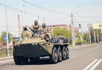  ?? LYNSEY ADDARIO/THE NEW YORK TIMES ?? Ukrainian fighters roll through Kramatorsk on Friday in Ukraine’s eastern Donbas region.