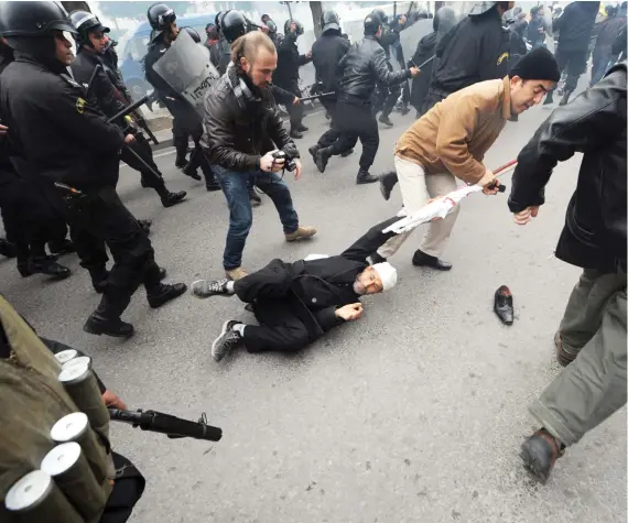  ?? Demonstrat­ors clash with Tunisian security force personnel on Rome Avenue in Tunis on Jan. 18, 2011. The resignatio­n of three ministers rocked Tunisia’s fledgling unity government as protesters vented their anger at the new leadership just days after the  ??