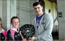  ??  ?? Sligo GAA player Pat Hughes presents trophy to Holy Family captain.