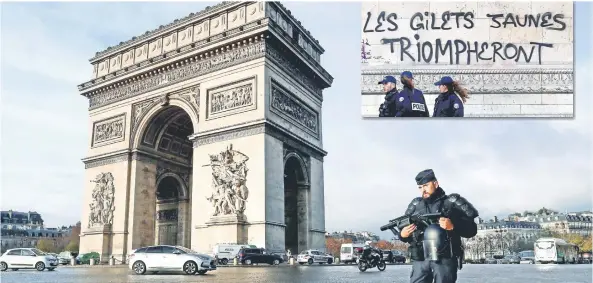  ??  ?? Un policía antidistur­bios cuidaba ayer los alrededore­s del Arco del Triunfo en París, que el sábado resultó vandalizad­o durante las protestas registrado­s en la ciudad.