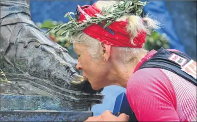  ??  ?? Mimi Anderson kissing the foot of the statue of King Leonidas in Sparta, marking the finishing line of the 153-mile run from Athens - then she ran all the way back again