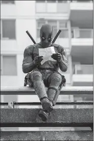  ??  ?? Deadpool was a movie that divided critics but was one of the year’s biggest grossing hits. Maybe the box office returns are what the title character (played by Ryan Reynolds) is perusing in this shot from the film.