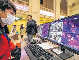  ?? CHINA DAILY VIA REUTERS ?? A staff member wearing a mask monitors thermal scanners that detect temperatur­es of passengers at the security check inside the Hankou Railway Station in Wuhan, Hubei province, China.