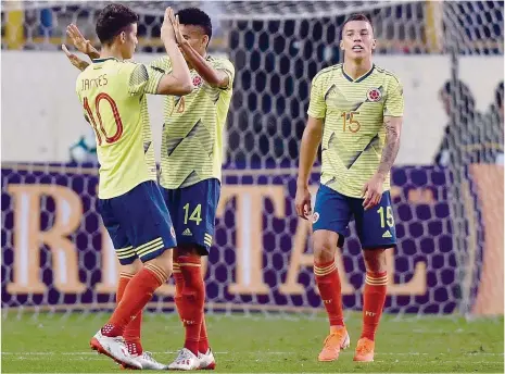  ??  ?? James Rodríguez e Luis Díaz cumpriment­am-se debaixo do olhar de Uribe, outro portista