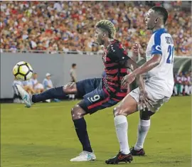  ?? Mike Carlson Getty Images ?? PLAYING FOR the United States, the Galaxy’s Gyasi Zardes keeps the ball away from Martinique’s Sebastien Cretinoir during the first half of Wednesday’s game.