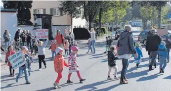  ?? FOTO: SIMON SCHNEIDER: ?? Kinder und Erzieher des Nendinger Kindergart­ens protestier­ten kürzlich auf der Straße vor dem Kindergart­en: Sie wollen die Rechts-vor-links-Regelung behalten.