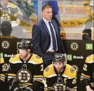  ?? Steven Senne / Associated Press ?? Bruins coach Bruce Cassidy, top, watches from the bench in Game 4 of a Stanley Cup first-round playoff series against the Hurricanes on Sunday.