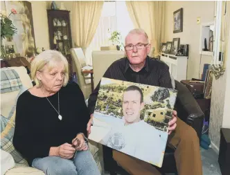  ??  ?? Linda and Dan Golden with a picture of their son Frazer, who was killed after a collision on his motorbike.