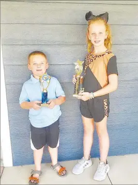  ?? Submitted Photo ?? Jace Dillon and his sister Danielle display trophies they won in competitio­n at the 2022 Benton County Fair. The siblings are active in various 4-H projects and show both beef heifers and goats in livestock shows. They were winners this year at both the county fair and the Arkansas Youth Expo the next weekend in Fayettevil­le.