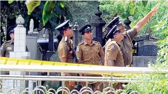  ??  ?? A drone was used to photograph the coverage around the exhumation of slain journalist Lasantha Wickrematu­nge’s body in Colombo. Seen here are policemen at the scene.