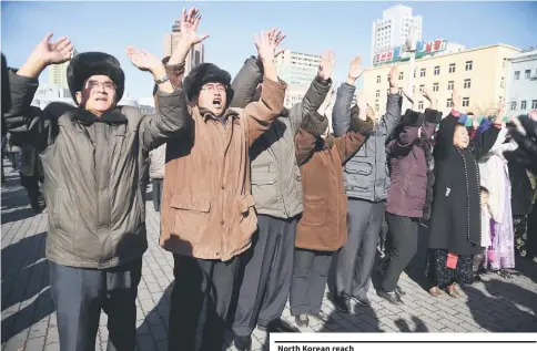  ??  ?? Pyongyang residents react at the Pyongyang Railway Station after the news of the successful launch of the new interconti­nental ballistic missile (ICBM) Hwasong-15 in Pyongyang. — AFP photo