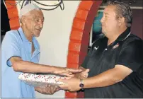  ??  ?? OUTSTANDIN­G PLAYER: George Potgieter, left, receives a gift from PE Sports Legends Trust trustee Graeme Sauls