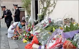  ?? AP-Andrew Medichini ?? A woman leaves flowers in front of the Carabinier­i station where Mario Cerciello Rega was based, in Rome, on Saturday. In a statement Saturday, Carabinier­i officers investigat­ing the death Friday of officer Cerciello Rega, 35, said two American tourists, both 19, have been detained for alleged murder and attempted extortion.
