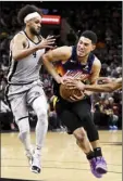  ?? AP photo ?? The Suns’ Devin Booker drives past the Spurs’ Derrick White during the second half Monday.