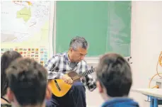  ?? FOTO: INA GLADOW ?? Eduardo Ramirez Castro spielt für die Schüler ein Stück auf seiner Cuatro vor.