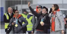  ??  ?? So viele deutsche Medaillen-Selfies wird es nicht allzu häufig geben. Wie hier bei Eric Frenzel (Mitte) und Eishockey-Nationalsp­ieler Christian Ehrhoff. Da bleibt Bob-Pilotin Mariama Jamanka nur ein neidischer Blick.