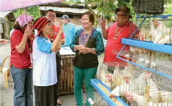  ??  ?? Agrarian Secretary Rosalina Bistoyong listens to agrarian reform beneficiar­y Gloria Aguilar explains the strategies she will employ to sustain and expand the egg-laying chickens with egg dispersal machines project she received during the turnover...