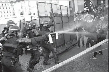  ?? AP/KAMIL ZIHNIOGLU ?? Police officers spray gas on demonstrat­ors during a protest Sunday in Paris.