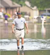  ?? BRIANNA PACIORKA. AP ?? Roger Brown walks down flooded Woodlawn Acres Avenue in Baton Rouge, La., on Aug. 16.