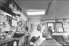 ?? AP/ROBERT F. BUKATY ?? Seth Morrill glances up at a TV monitor televising the impeachmen­t hearings while getting his hair cut Wednesday in Portland, Maine. Morrill said the hearings are very important but he would not intentiona­lly carve time out of his day to watch them, saying he would catch up on the news later, via the Internet.