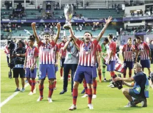  ?? AP ?? Varios jugadores del Atlético de Madrid festejan el triunfo de su equipo ante el Real Madrid.