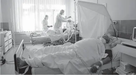  ?? EVGENIY MALOLETKA/AP ?? Medical staffers treat a COVID-19 patient Oct. 22 in the intensive care unit at the city hospital in Rivne, Ukraine.