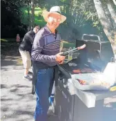  ??  ?? Mike Howell cooking sausages on the barbecue at the picnic.