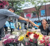  ?? MARK BLINCH/THE CANADIAN PRESS ?? Kaya Malcolmson, right, and Jowa Malcolmson, left, organize flowers at a memorial site rememberin­g the victims.