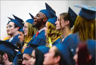  ?? SARAH GORDON/THE DAY ?? Merdoche Gustave, center, cheers for a fellow Norwich Technical High School Class of 2018 graduate during commenceme­nt exercises in the school’s gymnasium on Thursday. Go to www.theday.com for a list of graduates and more photos.