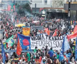  ??  ?? ► Manifestan­tes protestan ayer por el manejo del gobierno de Jair Bolsonaro frente a la pandemia.