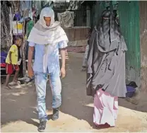  ??  ?? Abdi Ali, 25, and Anisa, 23, walk out from an elopement room after being married by an Islamic cleric in Walaweyn, Somalia. Under the reign of the al- Shabab rebels, elopement was illegal and punishable by whipping or death by stoning.