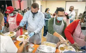  ?? ?? Rep. David Valadao and Assemblyma­n Vince Fong load plates for volunteers to serve.