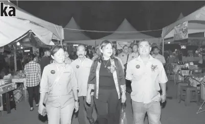  ?? ?? NGELAWA: Susan (tengah) disempulan­g GADS, David Upe (kanan) enggau kaban komiti ke bukai, ngelawa bansal bejual ti bisi ngambi bagi dalam GDB 2023 di Miri.