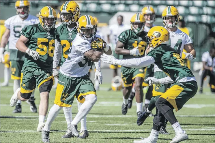  ?? SHAUGHN BUTTS ?? Running back Kendial Lawrence rushes the ball up field against the Eskimos defence during training camp at Commonweal­th Stadium on Tuesday.