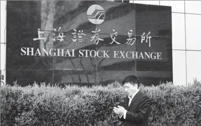  ?? PROVIDED TO CHINA DAILY ?? A pedestrian walks past the Shanghai Stock Exchange.