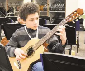  ?? David Hopper ?? Christophe­r Kar, a sixth-grader at Spring ISD’s Roberson Middle School, practices guitar during a music class at the campus.