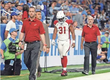  ?? JOSE JUAREZ/AP ?? Cardinals running back David Johnson walks off the field with the medical staff for X-rays during Sunday’s game against the Detroit Lions in Detroit. Johnson suffered a dislocated left wrist.