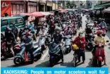  ?? ?? KAOHSIUNG: People on motor scooters wait for passing a campaign motorcade tour of Taiwan Vice President and presidenti­al candidate of the ruling Democratic Progressiv­e Party (DPP) Lai Ching-te in Kaohsiung on January 8, 2024, ahead of the presidenti­al election. — AFP