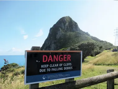  ??  ?? Above right: Warning sign on top of cliff, Paritutu Rock in background. Middle right: Entrance to the tunnel from the Herekawe Stream Walk. Below right: Exiting tunnel and onto Back Beach, car park in distance.