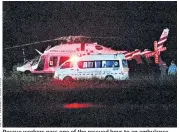  ??  ?? Rescue workers pass one of the rescued boys to an ambulance after their dive for freedom and, top, celebrate afterwards. Above, a helicopter carrying the boys lands at a military airport