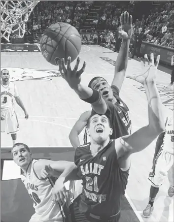  ??  ?? Saint Joseph’s forwards Ronald Roberts Jr (top), and Halil Kanacevic (21) compete for a rebound against Saint Louis forward Jake Barnett during the second half of their NCAA college basketball game, Feb 27, in St Louis. (AP)