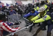  ?? JOHN MINCHILLO—ASSOCIATED PRESS ?? In this Jan. 6, 2021, file photo, rioters try to break through a police barrier at the Capitol in Washington.