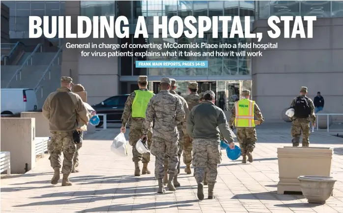  ?? TYLER LARIVIERE/SUN-TIMES ?? Illinois National Guardsmen, with hard hats and personal protective equipment in hand, walk to the entrance of McCormick Place on Thursday.