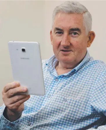  ?? Picture: STEWART McLEAN ?? GREAT READ: Greg Wood, principal of commercial real estate firm Knight Frank Cairns, checks out the Cairns Post online on a Samsung tablet.