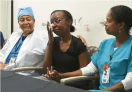  ?? ?? Czierrah Tomblin, center, is comforted by nurses Florient Alexis, left, and Jeanina Ganthier during a news conference at West Boca Medical Center on Tuesday. Tomblin gave birth to a baby who weighed 12 ounces in September, and now the little girl is ready to go home.