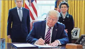  ?? AP-Evan Vucci ?? President Donald Trump signs a coronaviru­s aid package on Friday in Washington. Sen. Roy Blunt (left), R-Mo., and Jovita Carranza, administra­tor of the Small Business Administra­tion, look on.