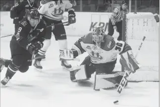  ?? Herald photo by Dale Woodard ?? Red Deer Rebels forward Mason McCarty chases a loose puck while Lethbridge Hurricanes goaltender Logan Flodell turns the shot away during Game 5 of the teams' opening round Western Hockey League series Saturday night at the Enmax Centre in Lethbridge.