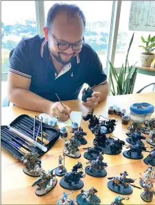  ??  ?? dideon paints a Warhammer figurine.